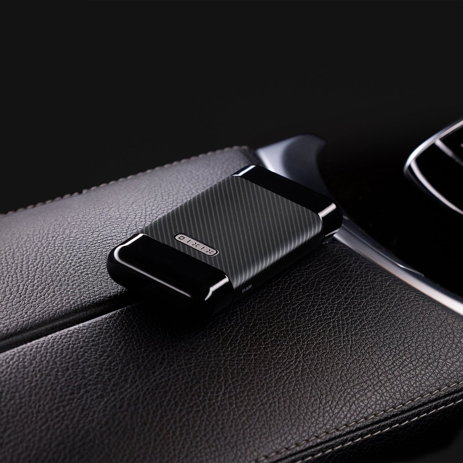 Black car phone holder attached to a car's air vent.